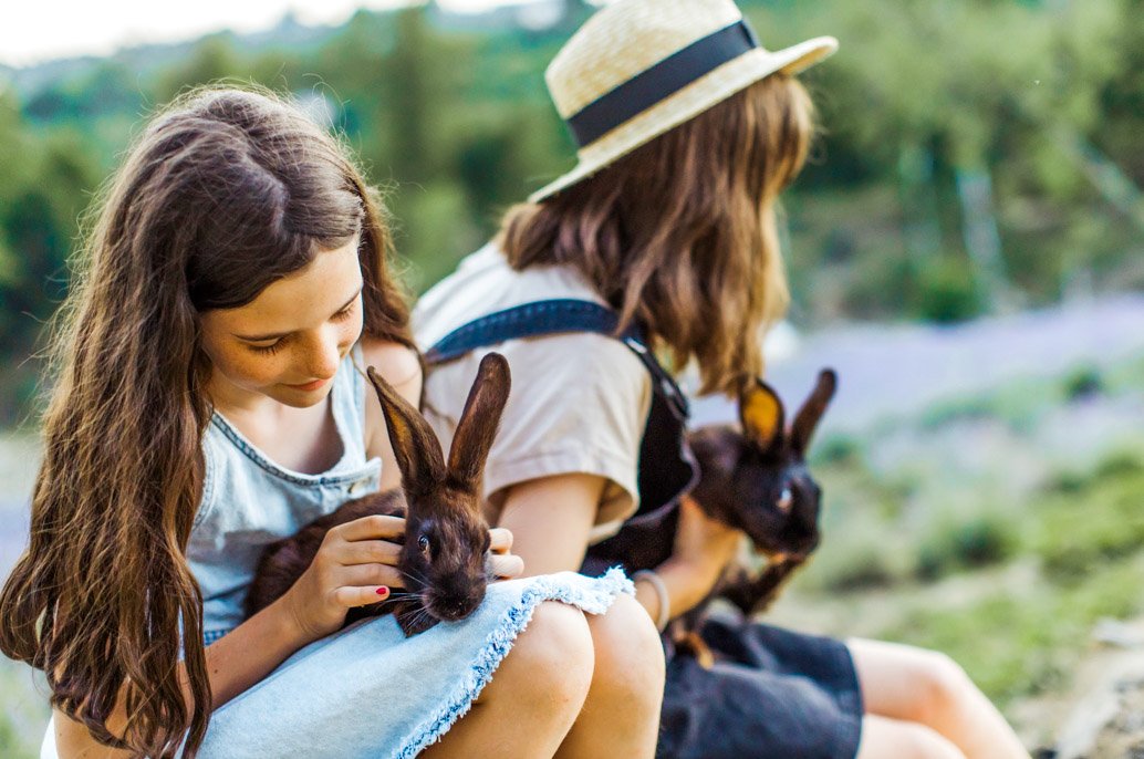 Enfants avec des lapins dans les bras